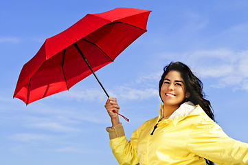 Image showing Beautiful young woman in raincoat with umbrella