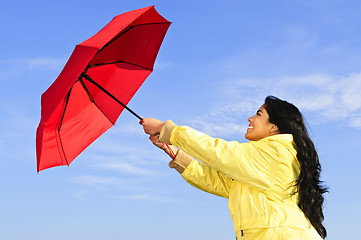Image showing Beautiful young woman in raincoat with umbrella