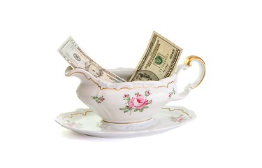 Image showing Vintage porcelain sauce-boat with dollar bills isolated 