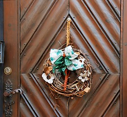 Image showing Dry old wreath on brown wooden door