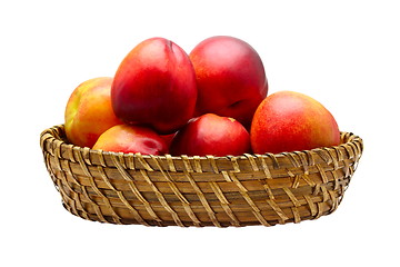 Image showing Basket full of fresh peaches isolated on white background