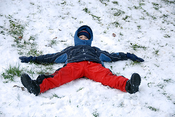 Image showing Young boy sit on snow.