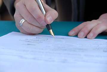 Image showing Businessman is signing a contract