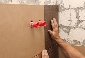 Image showing laying ceramic tile on wall