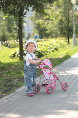 Image showing little girl walks with toy sidercar
