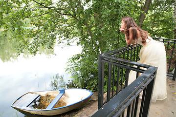 Image showing pensive girl ashore calm lake