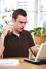 Image showing Confused man paying bills