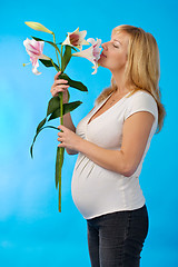 Image showing happy pregnant woman with flower