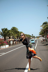 Image showing The woman tries to stop the car on road