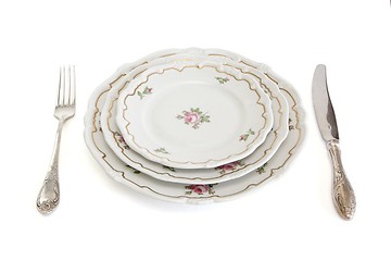 Image showing Dinner set with three plates, knife and fork isolated