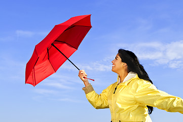 Image showing Beautiful young woman in raincoat with umbrella