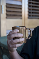 Image showing Man holding a hot drink in a mug