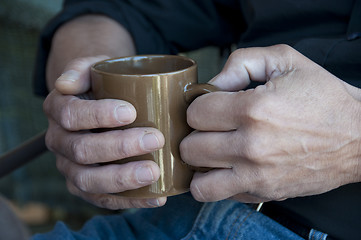 Image showing Man holding a hot drink in a mug