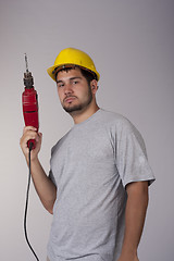 Image showing Cool worker with protective helmet and drill