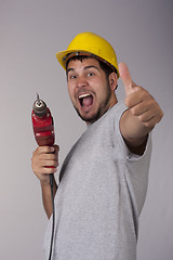 Image showing Happy worker with protective helmet and drill