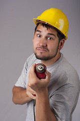 Image showing Freakish worker with yellow protective helmet and drill