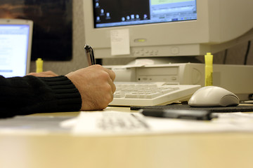 Image showing Signing a Document on a Messy Desk