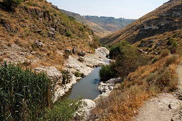 Image showing Narrow stream flows in stone banks