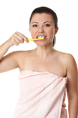 Image showing Female brushing her teeth with tooshpaste and toothbrush