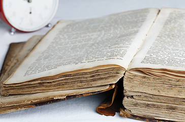 Image showing Old book and analog clock.