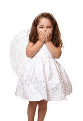 Image showing Little angel girl with hands covering her mouth