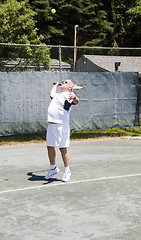 Image showing middle age tennis player serving the ball on court