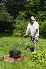 Image showing man cutting grass at suburban house