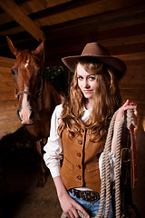 Image showing Beautiful caucasian cowgirl with a horse