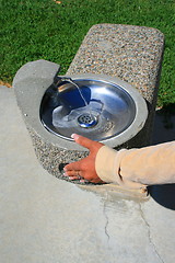 Image showing Hand Pushing Water Fountain