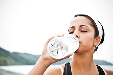 Image showing Sporty woman drinking water