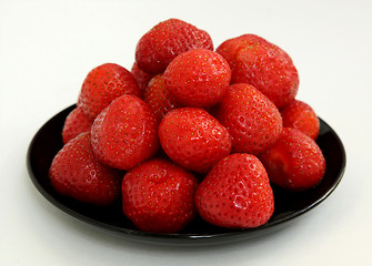 Image showing Ripe berries of a strawberry on black saucer