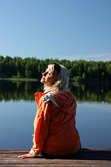 Image showing The girl meets morning on the shore of the river