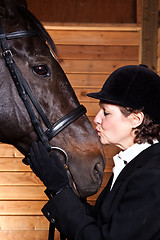 Image showing Senior woman kissing her horse