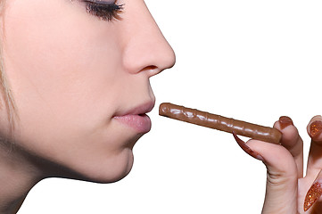 Image showing Female hand hold chocolate at lips 