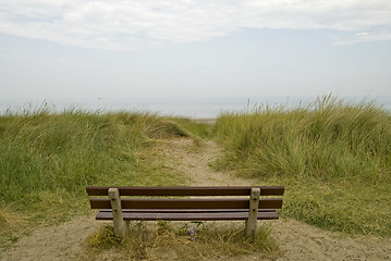 Image showing An empty bench in the dunes looking out to sea