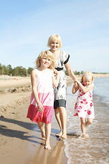 Image showing Mother and daughters at beach.