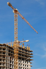 Image showing yellow tower crane building a multistory