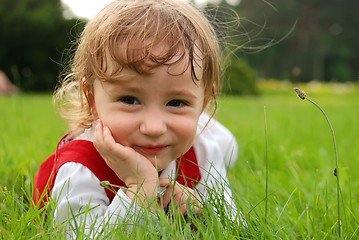Image showing Close-up little girl on the green grass outdoor
