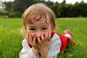 Image showing Close-up view of little girl laughing with hands on the mouth 