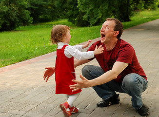 Image showing Laughing man (father) playing with little girl (daughter)