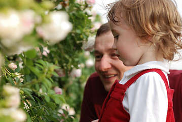 Image showing little girl, her father and flowers