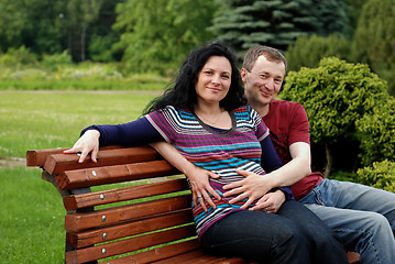 Image showing Young happy couple (pregnant woman) on bench