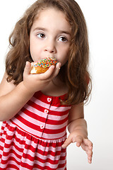 Image showing Pretty little girl eating a doughnut