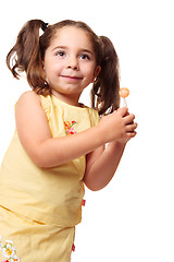 Image showing Little girl in ponytails holding a lollipop