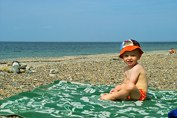 Image showing The boy sits on seacoast