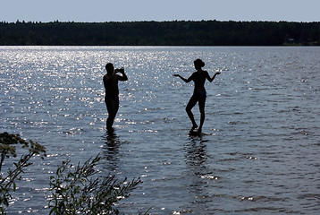 Image showing Man photographes the girl. Silhouettes