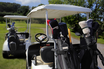 Image showing Two golf cart with clubs ready to go