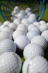 Image showing Golf balls pouring out of basket onto grass