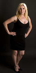 Image showing glamorous middle age woman posing in black dress