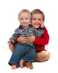 Image showing Two Brothers Smiling and Sitting Together on White